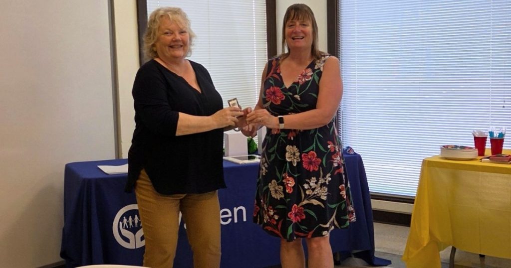 Warren Coalition Executive Director Christa Shifflett presents Holly Goode with a pin recognizing her as the Coalition Member of the Year.