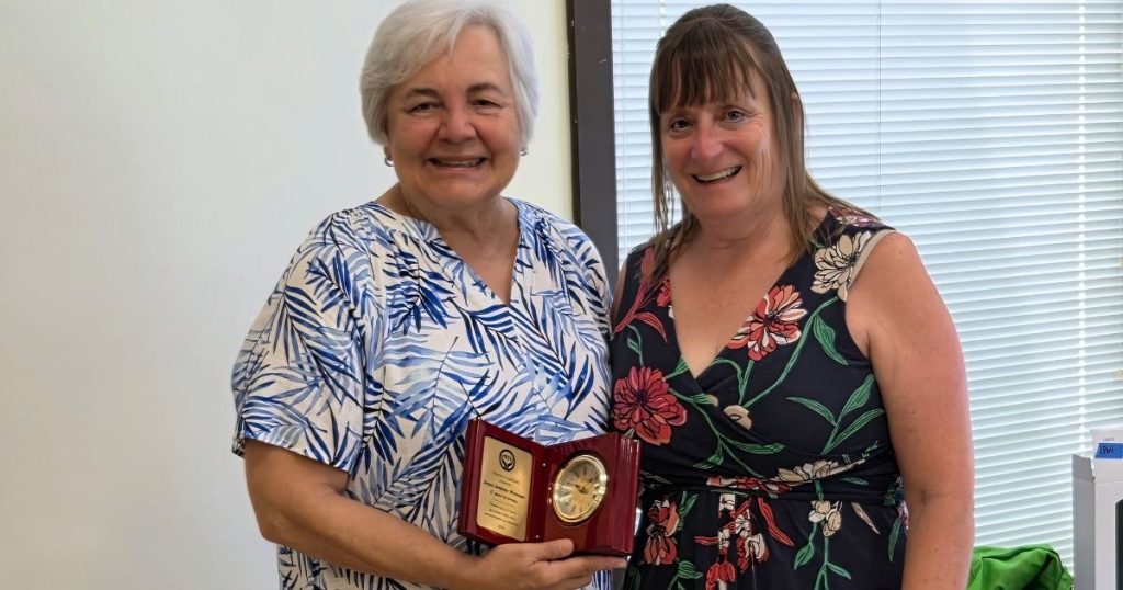 Warren Coalition Executive Director Christa Shifflett presents Joyce Jenkins-Wimmer with an inscribed clock recognizing Joyce's contributions to the Coalition over the past 17 years.