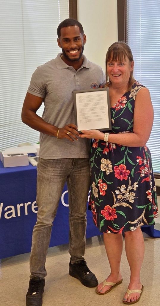 Warren Coalition Executive Director Christa Shifflett presents Dr. Matthew Rosario with the write-up of his nomination for the Larry M. Funk Memorial Award for Outstanding Service to Children in Warren County.